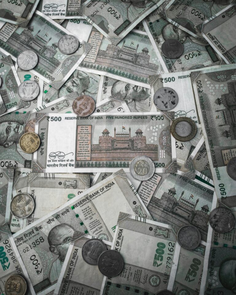 A detailed flat lay of various Indian rupee banknotes and coins, showcasing currency diversity.